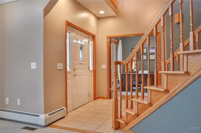 tiled foyer with a baseboard heating unit