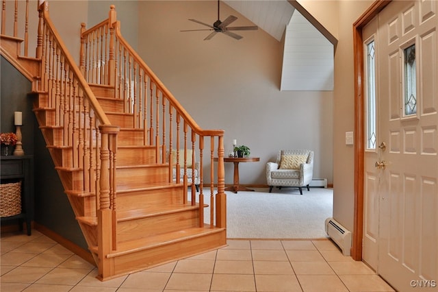 carpeted foyer entrance with a baseboard radiator, high vaulted ceiling, and ceiling fan