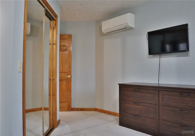 hall with light carpet, a textured ceiling, and an AC wall unit