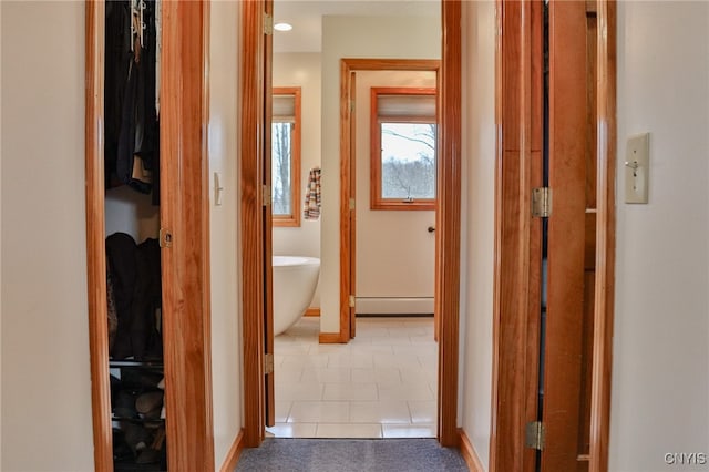 corridor with tile patterned flooring and baseboard heating