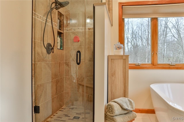 bathroom with tile patterned floors, a healthy amount of sunlight, and plus walk in shower