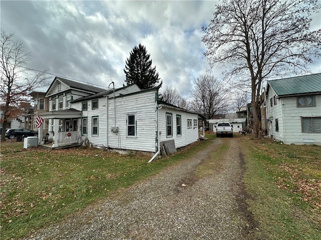 view of home's exterior with a yard and covered porch