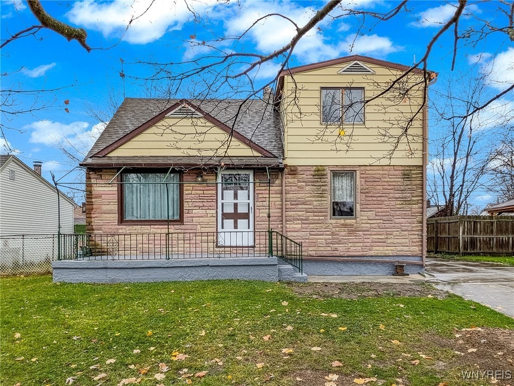 rear view of house featuring a lawn