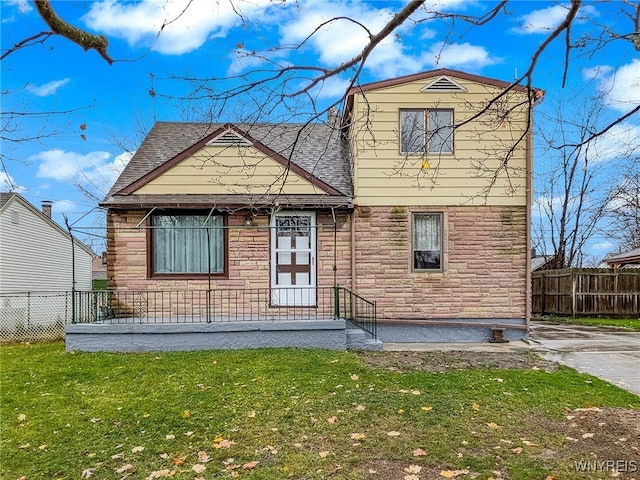 rear view of property featuring a lawn