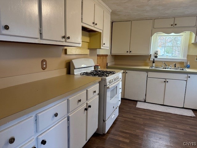 kitchen with white cabinets, sink, white gas range oven, dark hardwood / wood-style floors, and a textured ceiling