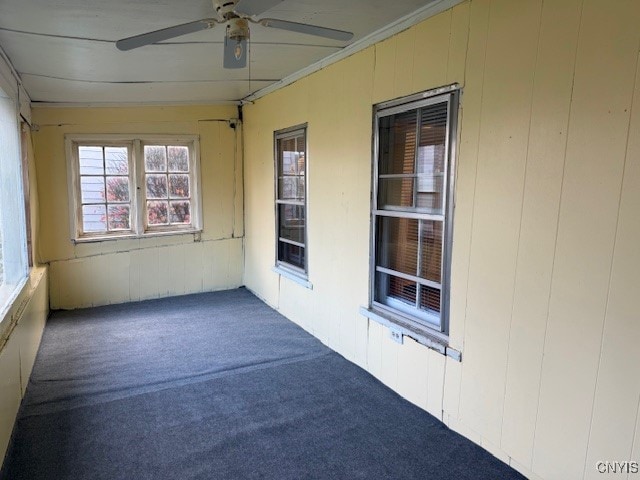 unfurnished sunroom with ceiling fan