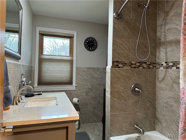 bathroom featuring shower / tub combo, vanity, and tile walls