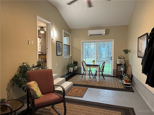 interior space with a wall mounted AC, lofted ceiling, and ceiling fan