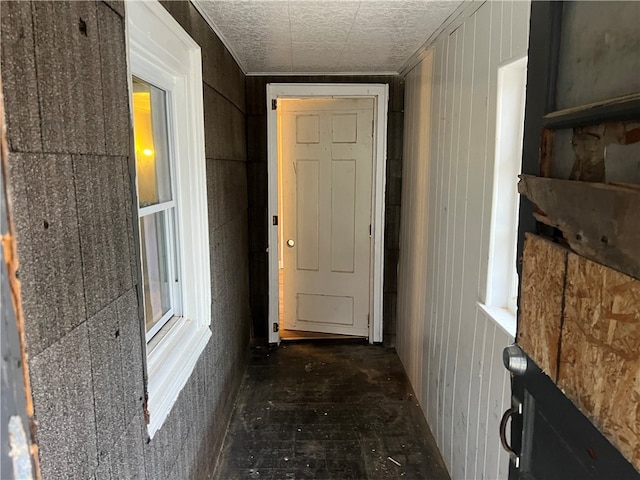 hallway featuring wooden walls