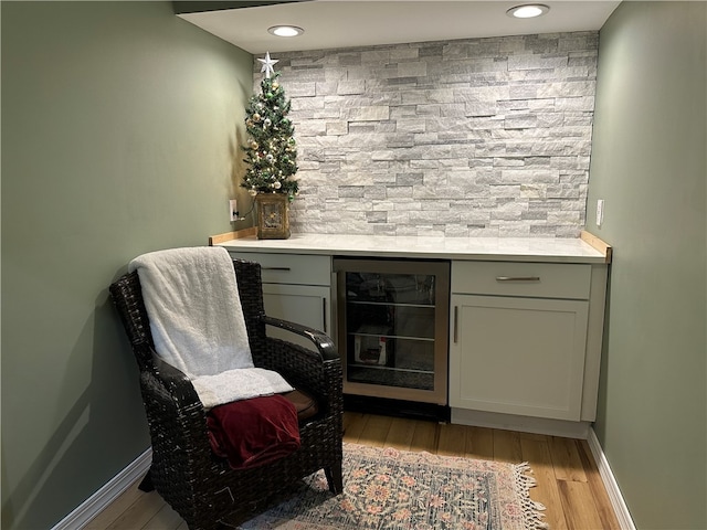 bar featuring wine cooler and light wood-type flooring