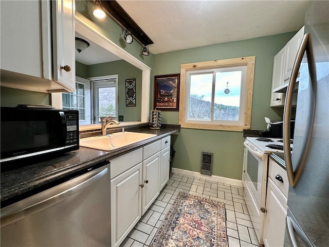 kitchen featuring white cabinetry, sink, a healthy amount of sunlight, and appliances with stainless steel finishes