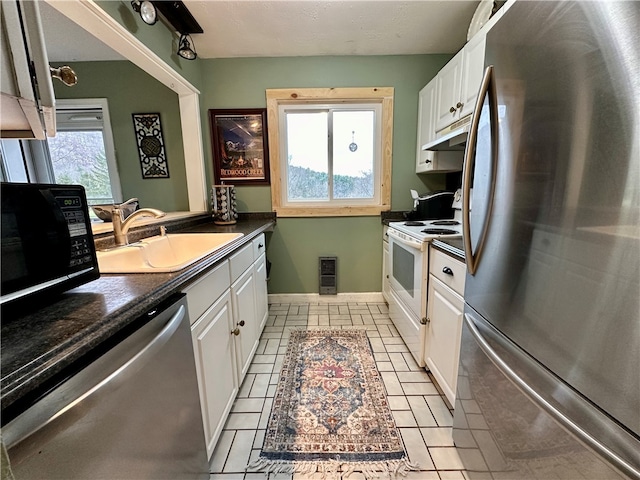 kitchen with white cabinets, sink, light tile patterned floors, and stainless steel appliances