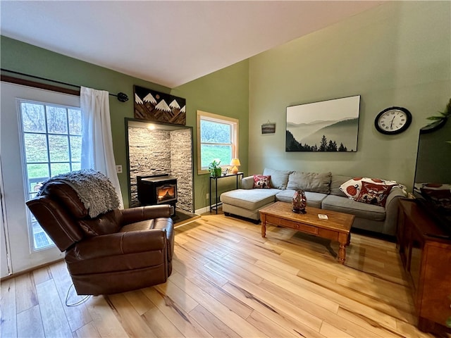 living room with a wood stove, a wealth of natural light, and light hardwood / wood-style floors