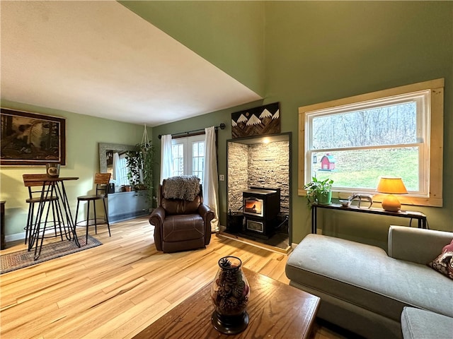 sitting room featuring a wood stove and light hardwood / wood-style flooring