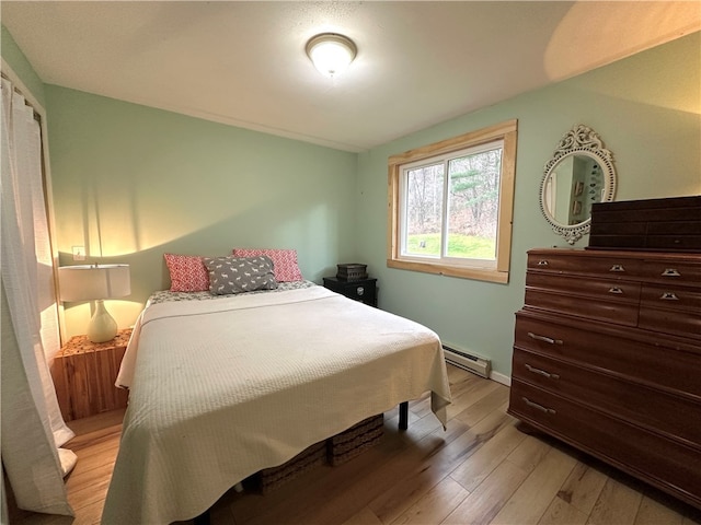 bedroom featuring baseboard heating and light wood-type flooring