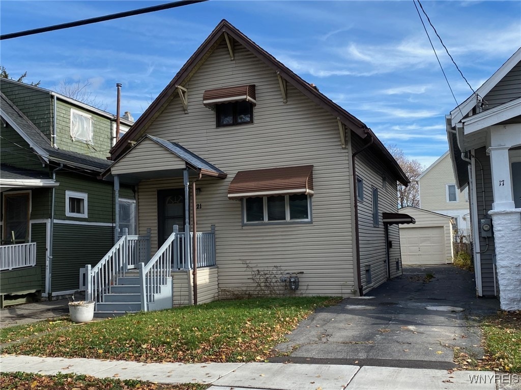 bungalow-style house with a garage and an outbuilding