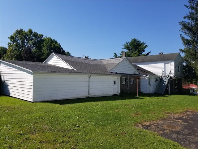 rear view of property featuring a lawn and a chimney