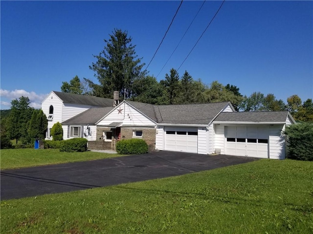 view of front of home featuring driveway, a front lawn, and an attached garage