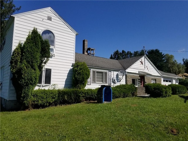 view of front of home with a front yard and stone siding