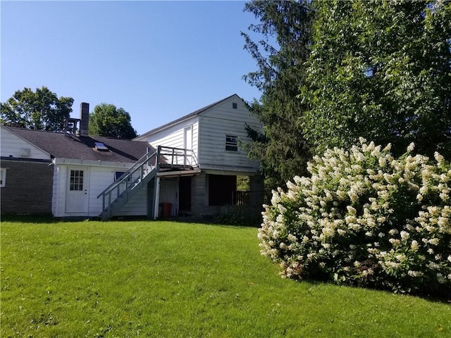 back of property with stairs and a yard