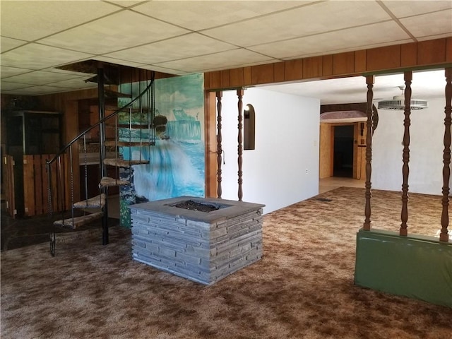 interior space featuring carpet floors, wood walls, stairway, and a paneled ceiling