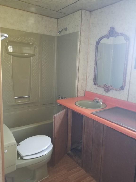 bathroom with toilet, shower / bathtub combination, wood finished floors, and vanity