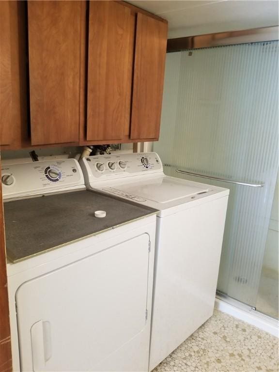 washroom with washing machine and dryer and cabinet space