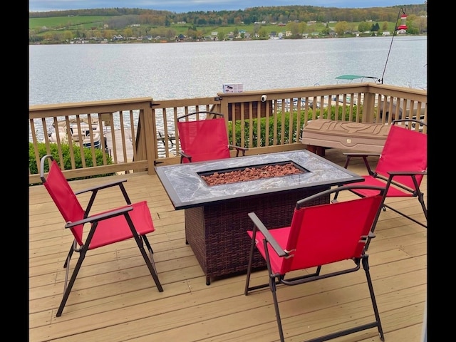 deck with a water view and an outdoor fire pit