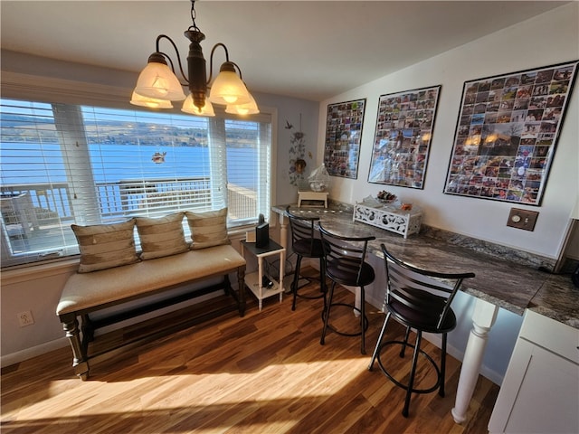 dining room with an inviting chandelier, vaulted ceiling, and light wood-type flooring