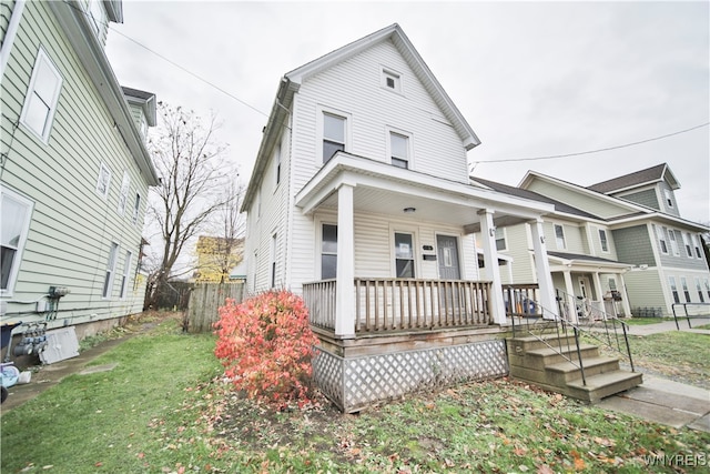 view of front of property featuring covered porch and a front lawn