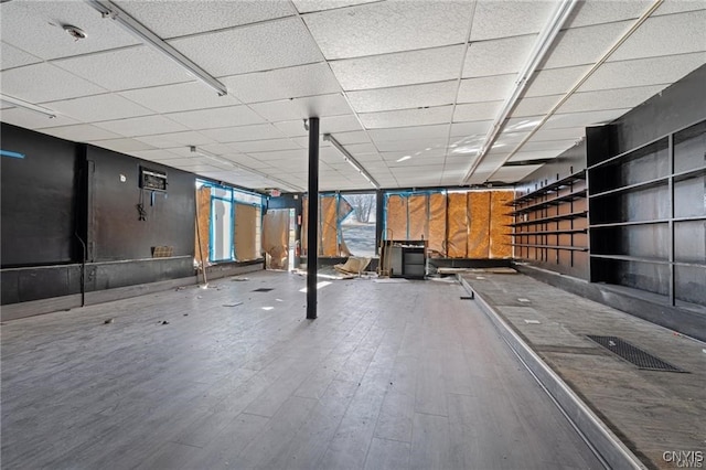 basement featuring a drop ceiling and wood-type flooring