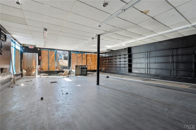 basement with wood-type flooring and a paneled ceiling