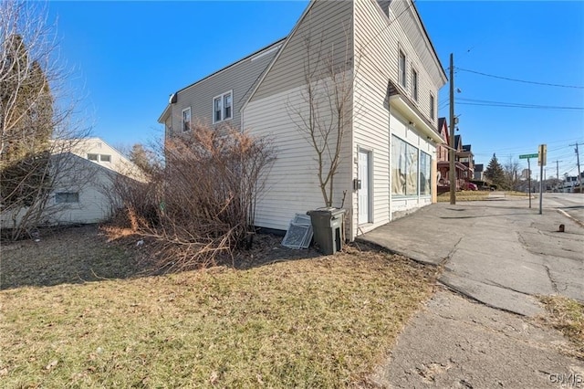 view of property exterior with a lawn and a patio area