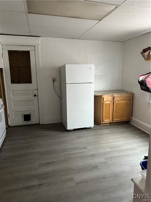 interior space featuring a paneled ceiling, white fridge, and light hardwood / wood-style floors