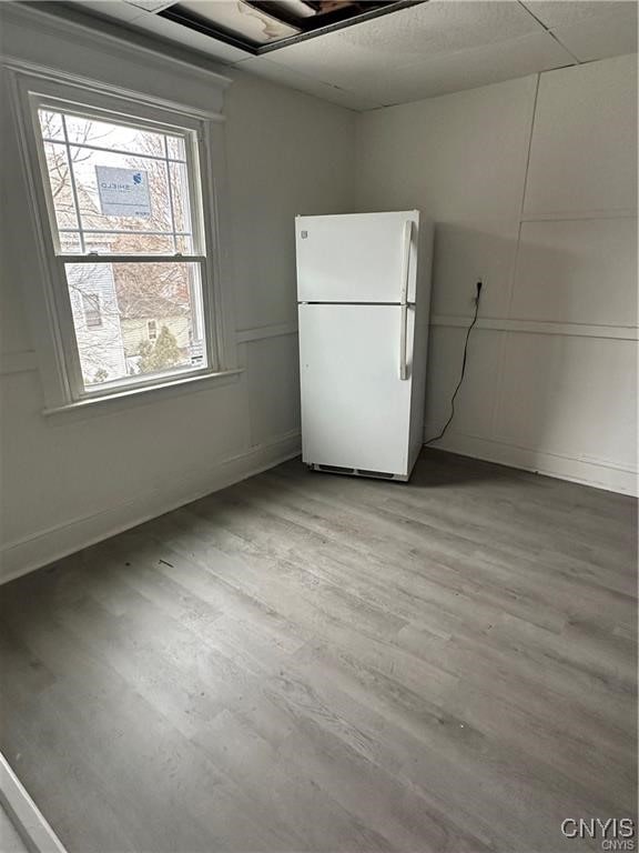 kitchen with plenty of natural light, white fridge, white cabinetry, and light hardwood / wood-style flooring