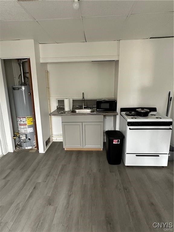 kitchen featuring white cabinets, dark hardwood / wood-style flooring, gas water heater, and white range