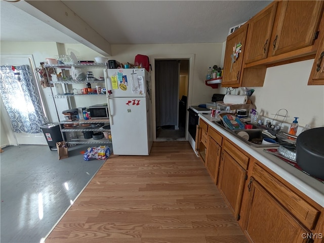 kitchen featuring white appliances, light hardwood / wood-style flooring, and sink