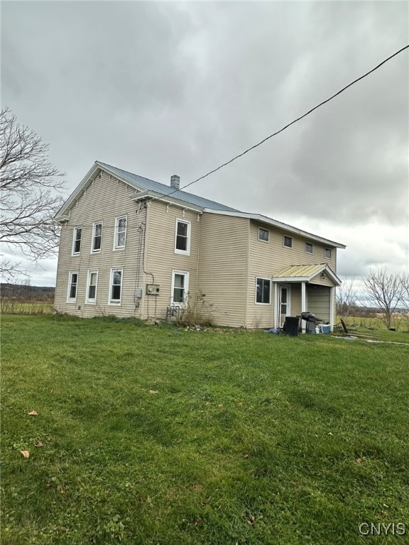 rear view of property featuring a lawn