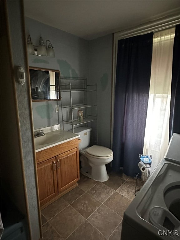 bathroom with tile patterned flooring, vanity, washer / clothes dryer, and toilet