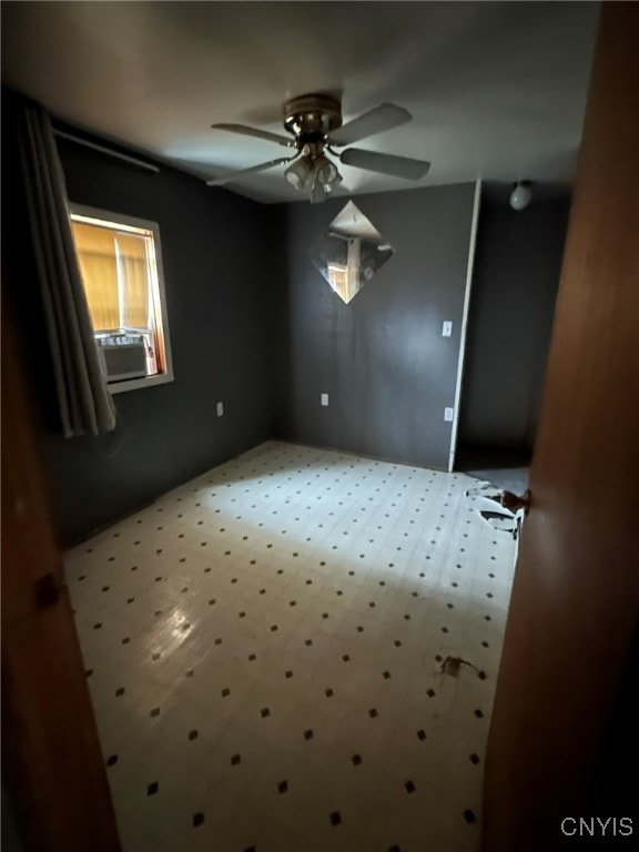 spare room featuring ceiling fan and cooling unit