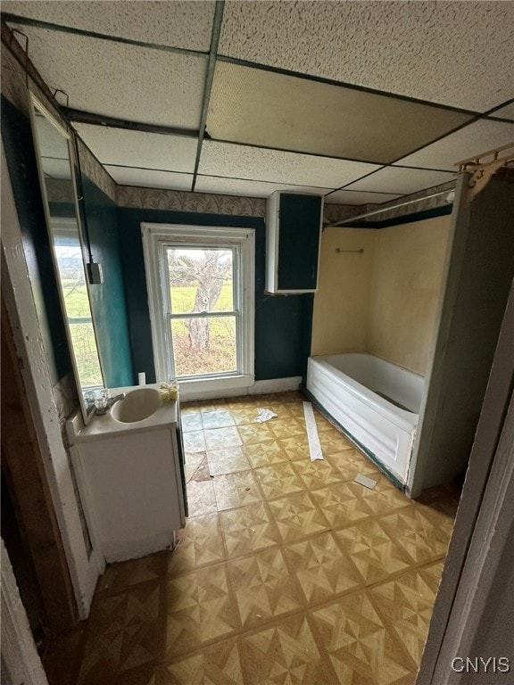 bathroom featuring a drop ceiling, vanity, and bathtub / shower combination