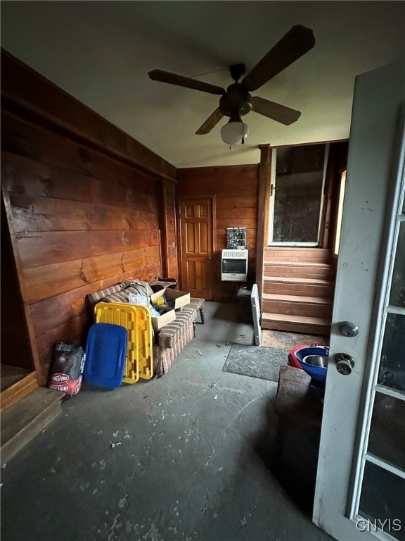 miscellaneous room featuring wooden walls and ceiling fan