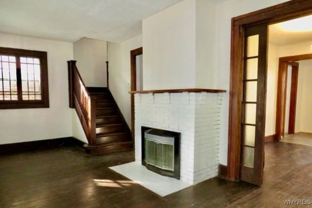 unfurnished living room featuring a fireplace and dark hardwood / wood-style flooring