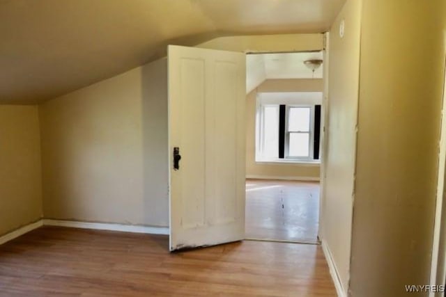 bonus room with lofted ceiling and light wood-type flooring