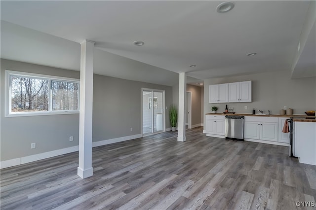 kitchen featuring light wood-type flooring, white cabinetry, stainless steel dishwasher, and sink