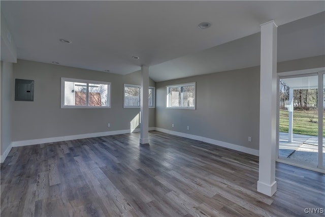 unfurnished living room with electric panel, a wealth of natural light, dark wood-type flooring, and lofted ceiling