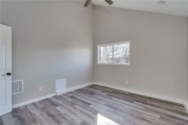 spare room featuring ceiling fan, light wood-type flooring, and high vaulted ceiling