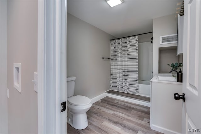 full bathroom featuring hardwood / wood-style flooring, vanity, toilet, and shower / bathtub combination with curtain