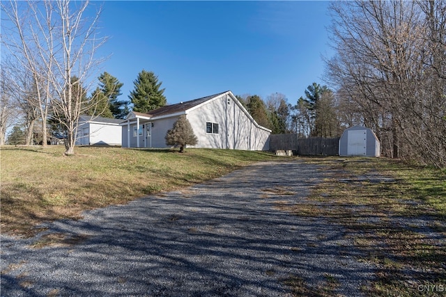 view of property exterior with a yard and a storage unit