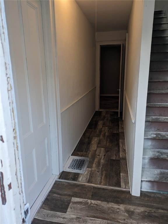 hall featuring wooden walls and dark wood-type flooring